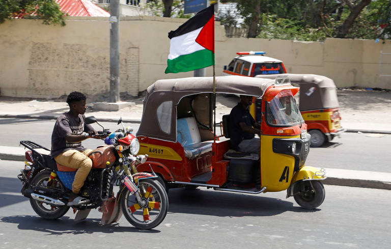foto mostra tuk-tuk, veículo motorizado com uma roda na frente e duas atrás, que leva bandeira da Palestina