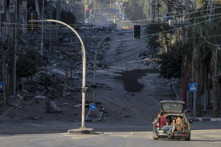Moradores da Cidade de Gaza fogem em um carro enquanto Israel continua os ataques aéreos na Faixa de Gaza
