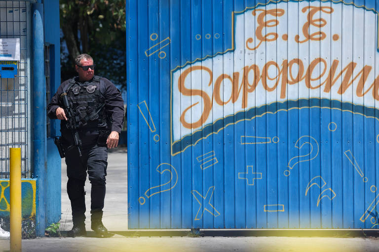 Policial na porta da Escola Estadual Sapopemba, na zona leste de São Paulo, após ataque a tiros na manhã desta segunda (23)