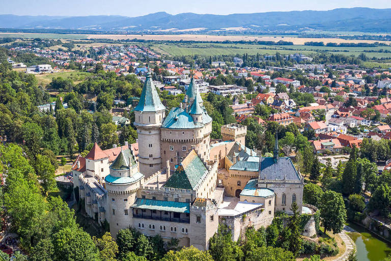 Castelo de Bojnice, um dos monumentos mais antigos e importantes da Eslováquia; também é possível visualizar residências da região, já que o castelo está na parte superior da imagem.