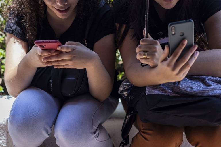 Duas garotas usando celular