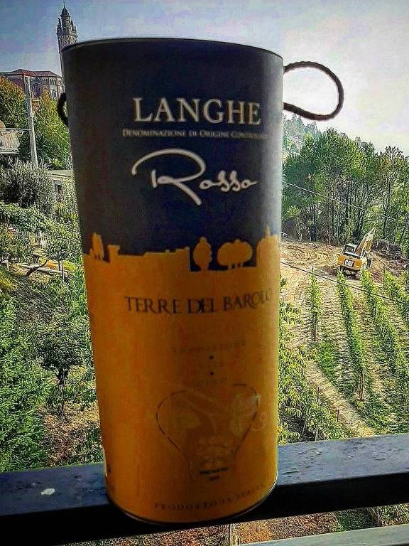 Caixa de vinho numa varanda com vinhedos atrás