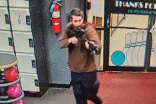 A still image from surveillance camera video shows a man with a gun in Lewiston