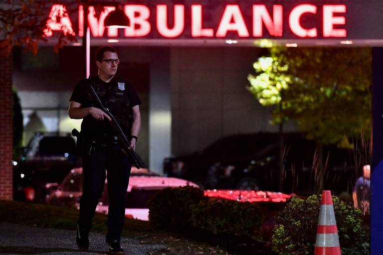 Policial em frente a hospital na cidade de Lewiston, em Maine, após atirador matar ao menos 22 pessoas
