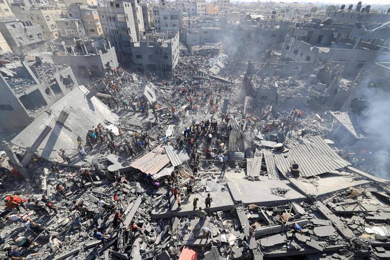 Pessoas procuram sobreviventes em meio a destroços de prédios em Khan Yunis, no sul de Gaza