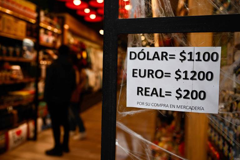 Placa exibe cotação do dólar, euro e real em vitrine de loja em Buenos Aires, na Argentina