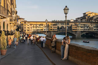 Visitors near the Ponte Vecchio over the Arno River in Florence, Italy, on Sept. 27, 2023.  (Susan Wright/The New York Times)