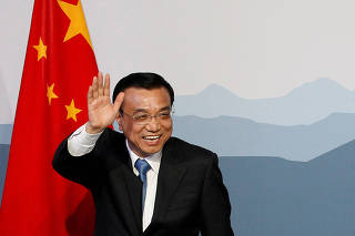 FILE PHOTO: Chinese Premier Li waves to media after a statement during the second day of an official visit to Switzerland in Bern