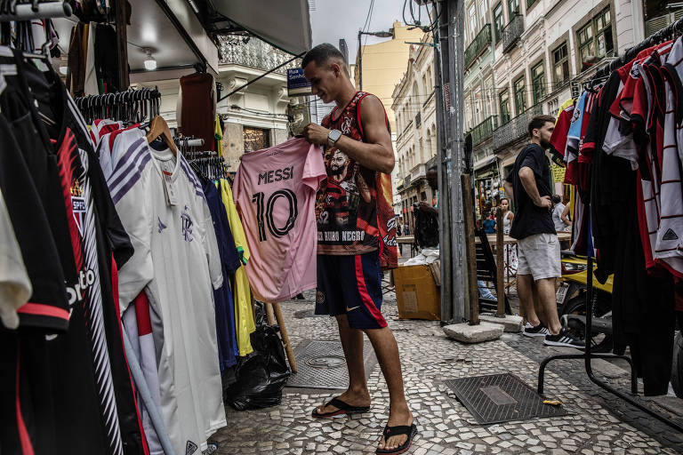 A shopkeeper with a Lionel Messi jersey, in Inter Miami?s distinctive pink color, at a shop Rio de Janeiro, Sept. 26, 2023. In the span of three months, the soccer superstar has made Inter Miami?s eye-catching pink jersey the hottest piece of sports merchandise on the planet. (Dado Galdieri/The New York Times)