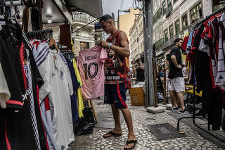 A shopkeeper with a Lionel Messi jersey, in Inter Miami?s distinctive pink color, at a shop Rio de Janeiro, Sept. 26, 2023. (Dado Galdieri/The New York Times)