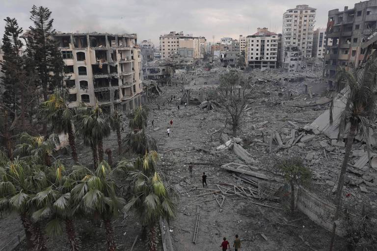 Palestinos verificam a destruição em massa no bairro do Rimal, em Gaza, após ataques áreos de Israel de 10 de outubro