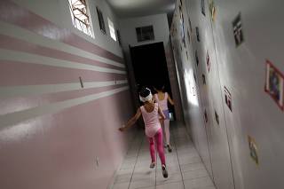 Young girls run at the New Dreams dance studio in the Luz neighborhood known to locals as Cracolandia (Crackland) in Sao Paulo