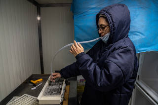 A biologist with a tray of frozen mosquitoes at a lab run by the World Mosquito Program, which helps to protect communities around the world from mosquito-borne diseases, in Cali, Colombia, Jan. 18, 2023. (Federico Rios/The New York Times)
