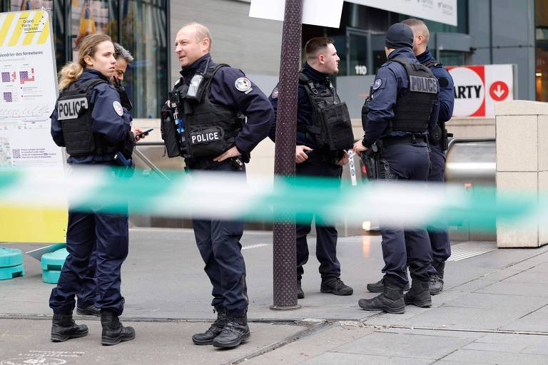 Policiais conversam em frente a estação de metrô após mulher ser baleada em Paris