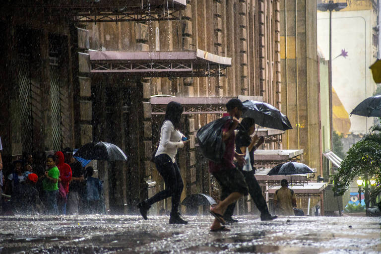 Pedestres enfrentam chuva no centro de São Paulo na tarde desta terça (31); previsão do Inmet diz que novembro será ainda mais chuvoso na região Sudeste