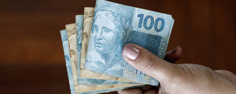 Hands holding Brazilian real notes, money from Brazil, notes of Real, Brazil BRL banknote, Brazilian currency, economy and business.