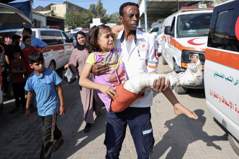 Menina palestina ferida é levada por enfermeiro para ser transferida ao Egito em Rafah, na Faixa de Gaza, no primeiro dia de saída de pessoas do território sob ataque de Israel