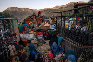 Afghan women and children wait for processing by authorities in a truck with their belongings upon returning from Pakistan, at the Torkham border crossing in eastern Afghanistan, Oct. 23, 2023. (Elise Blanchard/The New York Times)