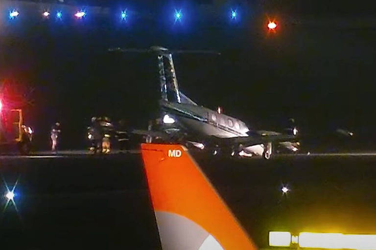 Imagem do avião de costas com o bico para baixo, à noite