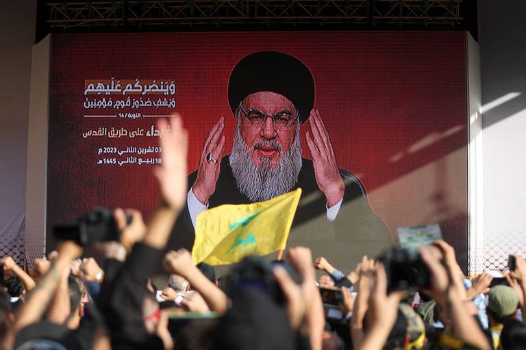 Libaneses apoiadores do Hezbollah assistem ao pronunciamento do líder do grupo, Hassan Nasrallah, em uma praça no sul de Beirute