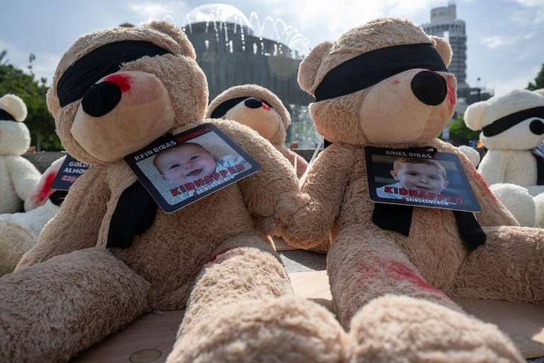 Alguns ursinhos de pelúcia com fotos de crianças sequestradas pelo Hamas