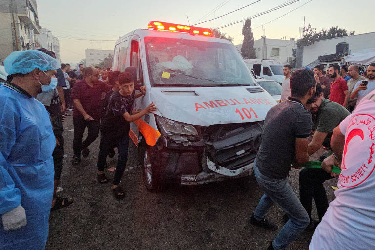 Palestinos puxam uma ambulância após um comboio de ambulâncias ser atingido, na entrada do hospital Shifa, na cidade de Gaza, em 3 de novembro de 2023