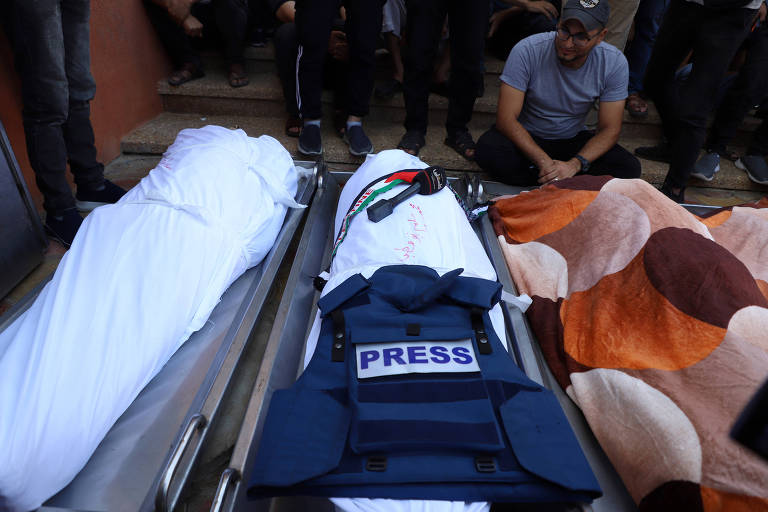 Homem lamenta a morte de Muhammad Abu Hatab, correspondente de TV palestino, em Gaza