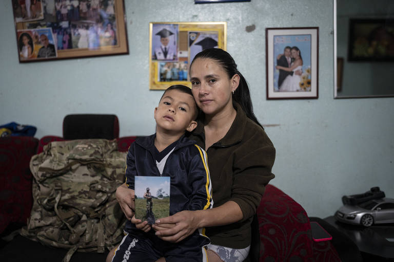 Paola Ortiz, com seu filho Daniel Herrera, mostram a foto de Alejandro Herrera, combatente colombiano morto na Ucrânia 
