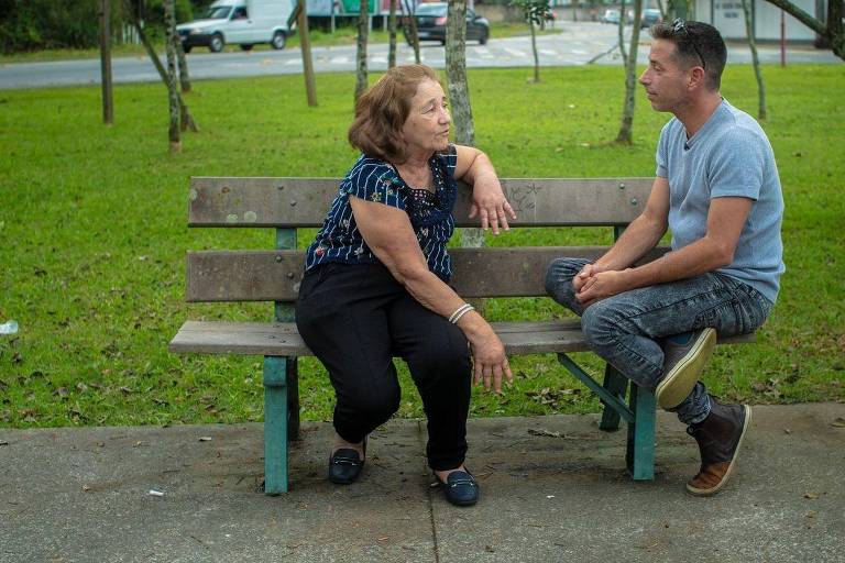 Mãe e filho conversam em banco de praça