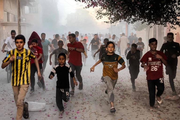 Crianças palestinas correm para longe de área atingida por Israel em Rafah, na fronteira com o Egito