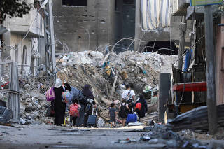 Palestinians carry their belongings as they flee their houses