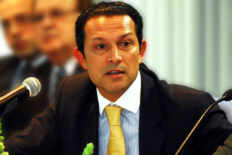 O juiz federal Danilo Pereira Júnior, um homem branco de cabelo curto preto, fala diante de um microfone, que aparece à esquerda da imagem