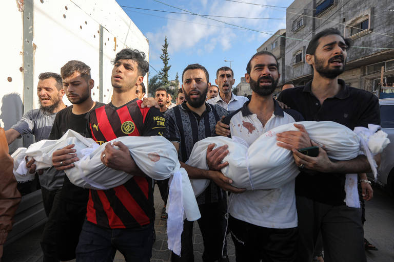Palestinos carregam corpos de crianças mortas em Khan Younis, na Faixa de Gaza, após bombardeio