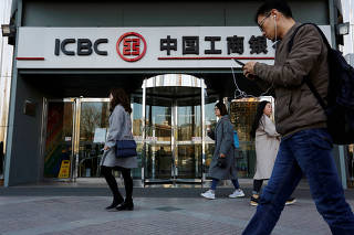 FILE PHOTO: People walk past a branch of Industrial and Commercial Bank of China (ICBC) in Beijing