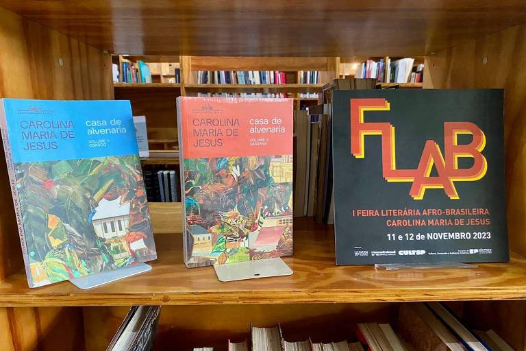 Estante de madeira com três livros, um deles leva o nome do evento: Flab, Feira Literária Afro-Brasileira Carolina Maria de Jesus