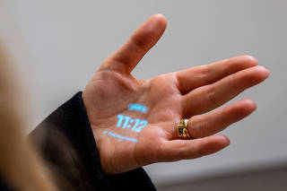 The Humane Ai PinÕs interface is projected onto the hand of company co-founder Bethany Bongiorno in San Francisco on Oct. 27, 2023. (Kelsey McClellan/The New York Times)