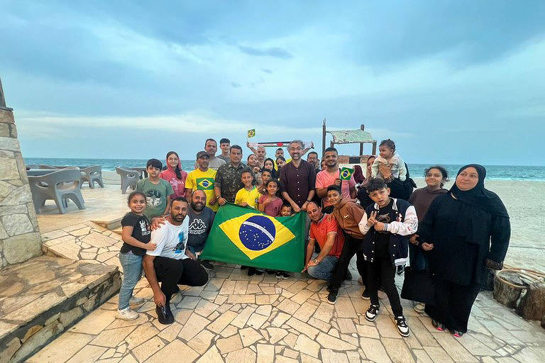 Já no Egito, o grupo de brasileiros e familiares posa ao lado de diplomatas e da equipe de resgate em al-Arish, onde pararam para almoçar antes de seguir para o Cairo