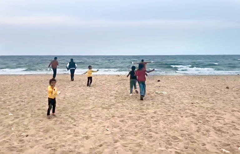 Na parada do almoço, Rabee filma as crianças resgatadas pelo Itamaraty correndo na praia