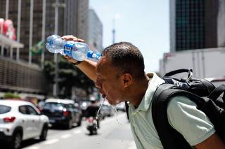 Homem se refresca na av. Paulista em novo dia de calor recorde em São Paulo
