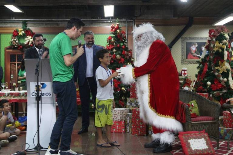 Menino entrega uma carta ao Papai Noel no lançamento da campanha Papai Noel dos Correios em São Paulo