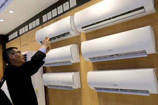 FILE PHOTO: A visitor takes a photo of Gree's air conditioners during the China Import and Export Fair, also known as Canton Fair, in the southern city of Guangzhou