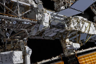 A photo provided by NASA shows Expedition 70 Flight Engineers Loral O?Hara, center, and Jasmin Moghbeli, right, tethered to the International Space Station?s port truss structure during a spacewalk on Nov. 1, 2023. (NASA via The New York Times)