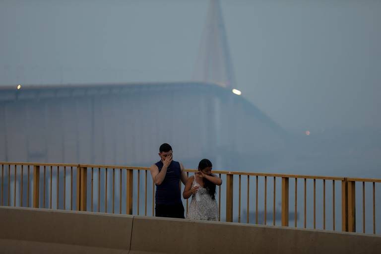 Um casal caminha na fumaça