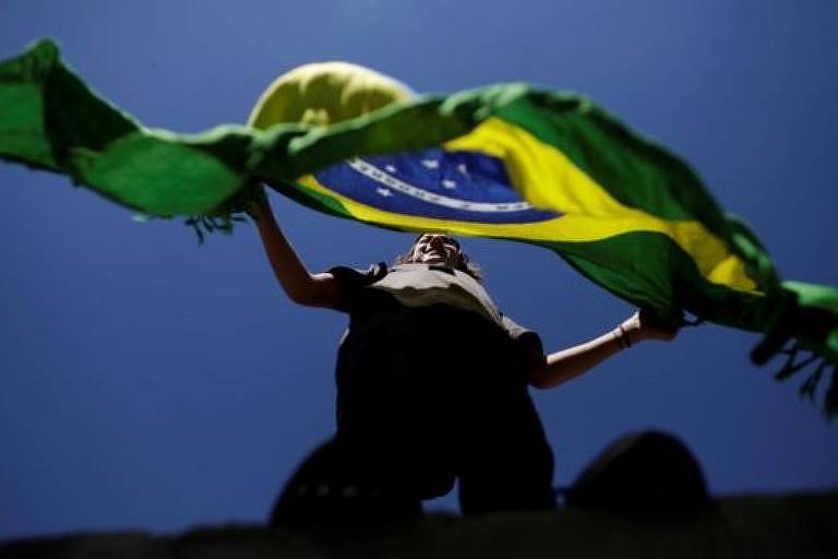 Mulher segura bandeira do Brasil