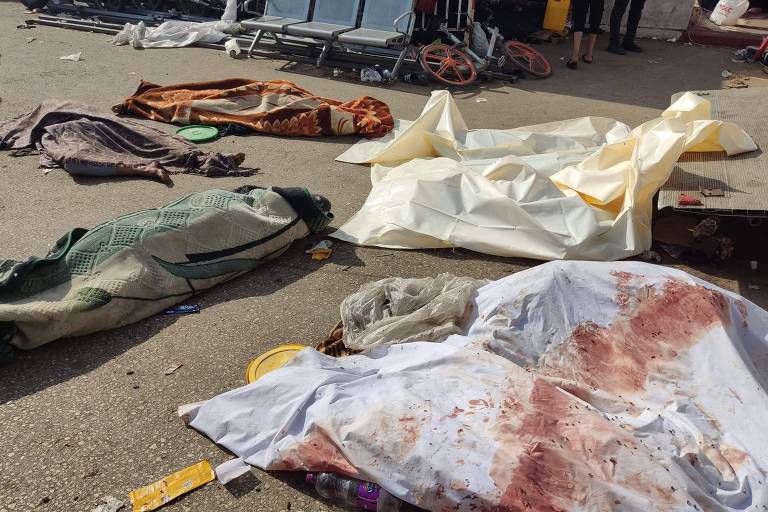 Corpos de palestinos mortos após ataque ao Hospital Al-Shifa cobertos com lençóis do lado de fora do centro de saúde na Cidade de Gaza, a mais populosa da faixa de terra homônima 
