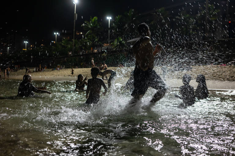 Banhistas curtem praia à noite no Rio