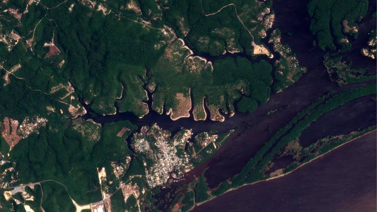 foto aérea mostra rio que se divide em cursos menores e encontra áreas urbanizadas