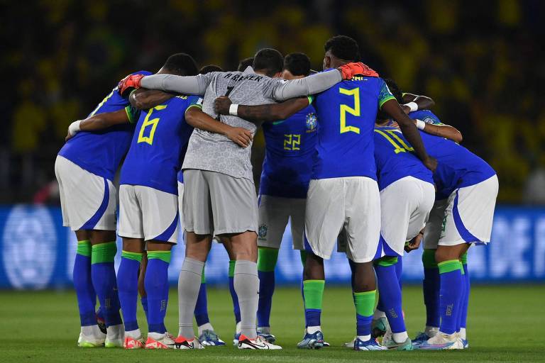 Vestidos com uniforme azul, jogadores da seleção brasileira que perderam da Colômbia em Barranquilla se reúnem, abraçados em círculo, antes do começo da partida 