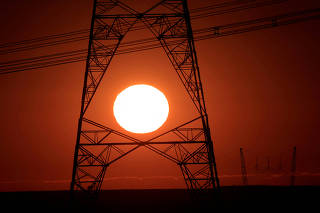 FILE PHOTO: Power lines connecting pylons of high-tension electricity are seen during sunrise near Brasilia