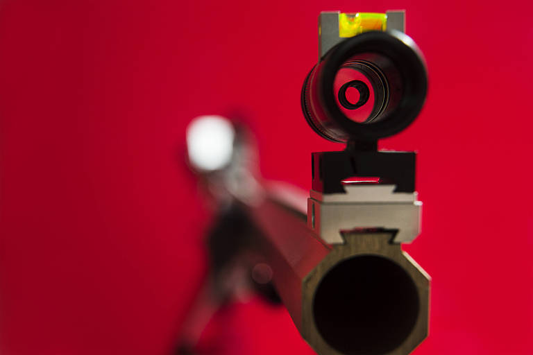 Arma vista de perto, com fundo vermelho
